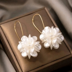 1 par de pendientes largos con diseños florales con pétalos blancos.