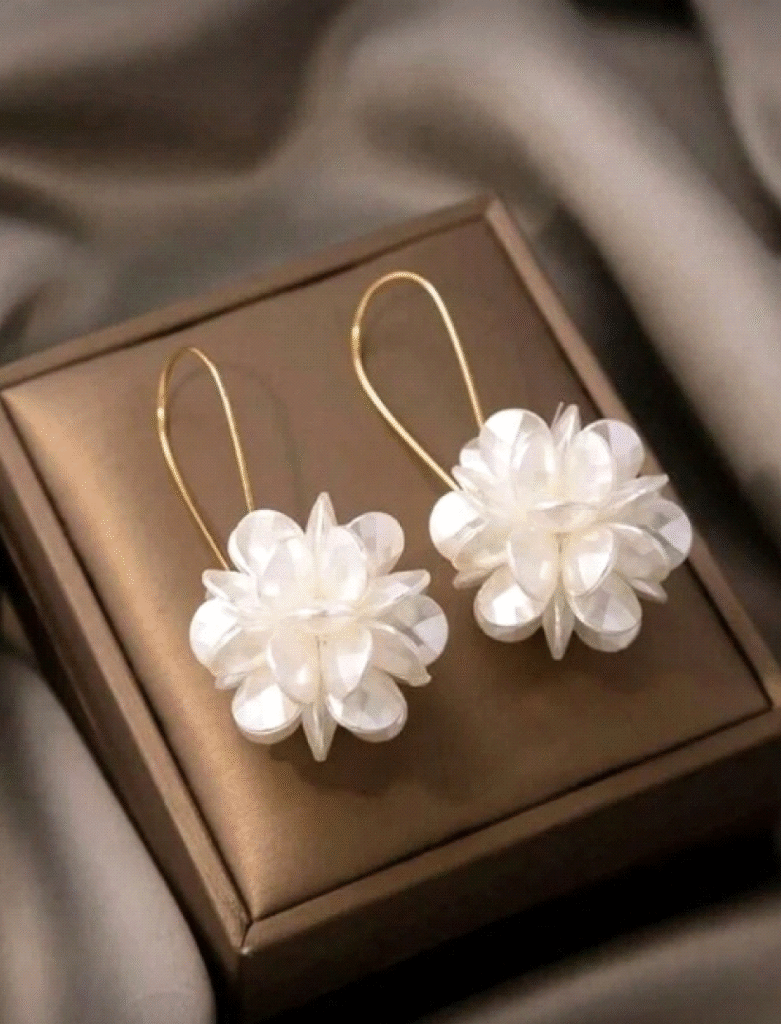 1 par de pendientes largos con diseños florales con pétalos blancos.